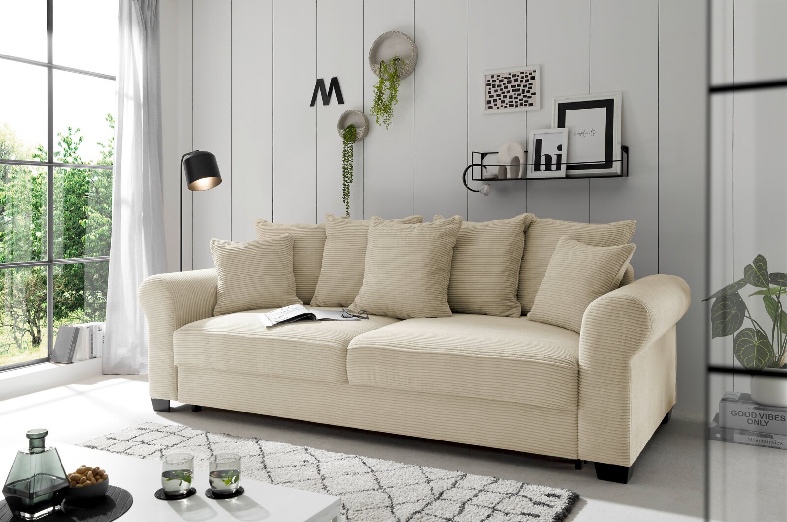 Hom´in Big Sofa MAUREEN Beiges Funktionssofa in einem modernen Wohnzimmer, seitliche Perspektive, mit Kissen und dekorativen Elementen.