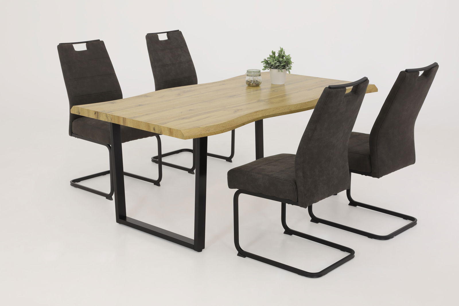 Essgruppe mit vier modernen Schwingstühlen und einem Holztisch aus seitlicher Perspektive