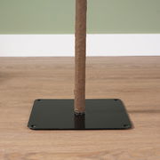 Nahaufnahme eines Baumstamms auf einer schwarzen Metallplatte, auf einem Holzboden stehend.