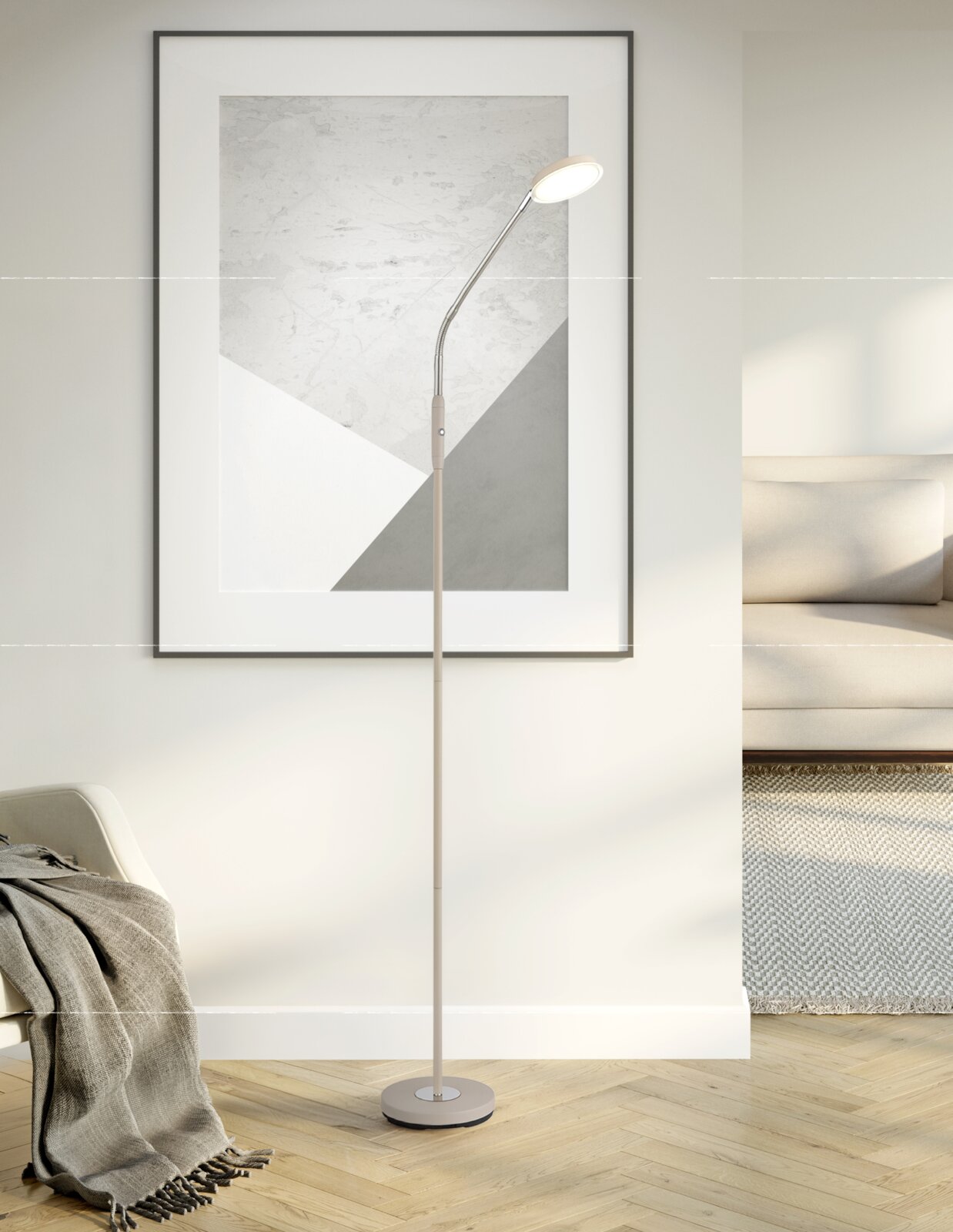 Beige LED-Stehlampe mit schlankem Stab, flexiblem Schwanenhals und rundem Leuchtenkopf auf rundem Standfuß, eingeschaltet, in moderner Wohnzimmerecke vor gerahmtem Wandbild – Frontalansicht