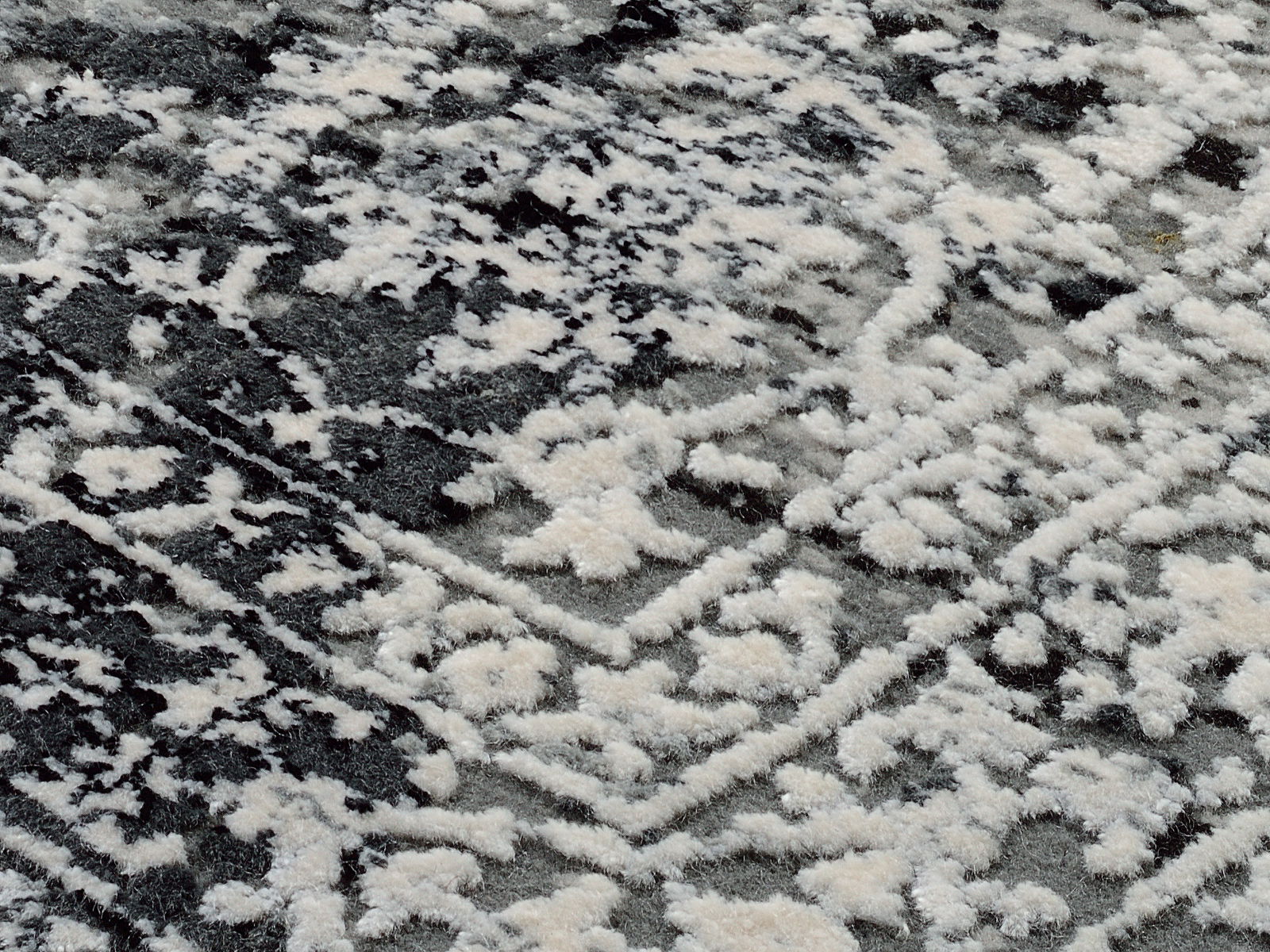 Nahaufnahme eines Designer-Teppichs mit schwarz-weißem Muster, diagonale Perspektive