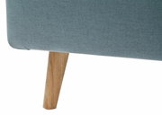 Nahaufnahme eines Polsterbettes mit blauer Stoffbespannung und Holzbein, seitliche Perspektive
