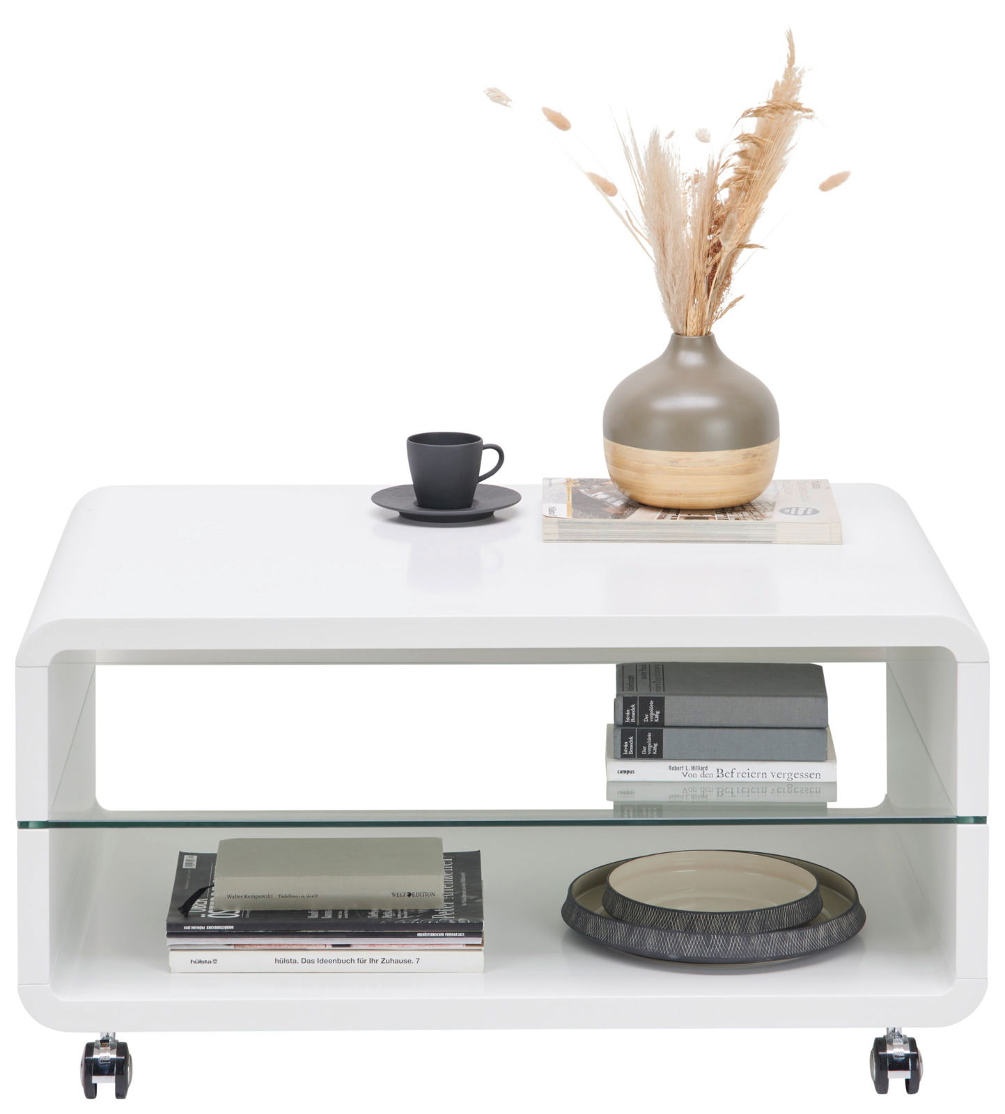 Moderner weißer Couchtisch mit abgerundeten Ecken, Glasablage und Rollen, dekoriert mit einer Vase und einer Tasse, Frontalansicht.