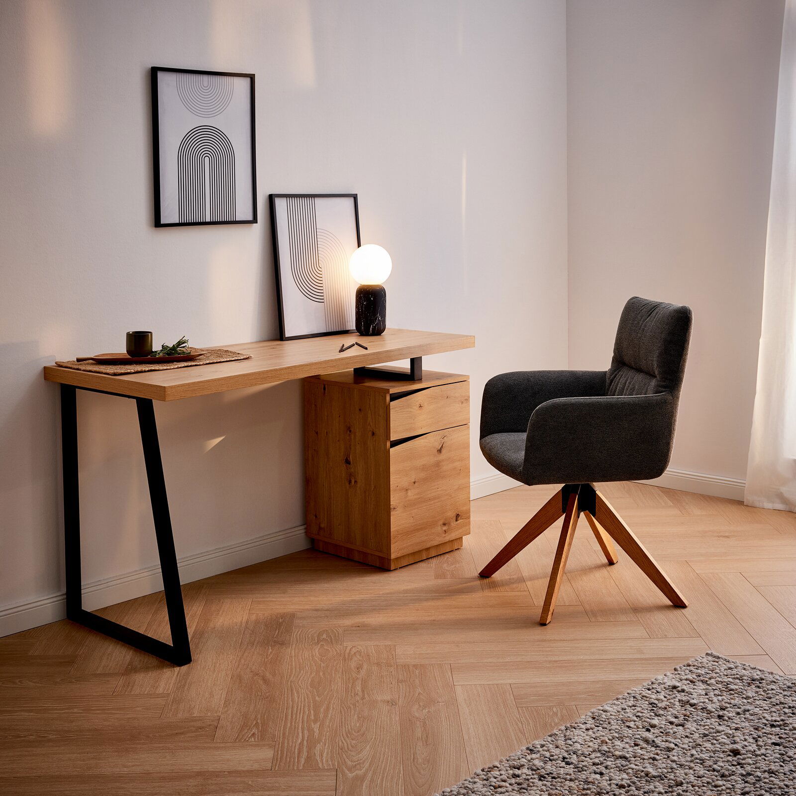 XORA Schreibtisch DANZIG Moderner Schreibtisch aus Holz mit schwarzem Metallgestell, seitlich mit Schubladenblock, dekoriert mit Bildern und Lampe, seitliche Perspektive