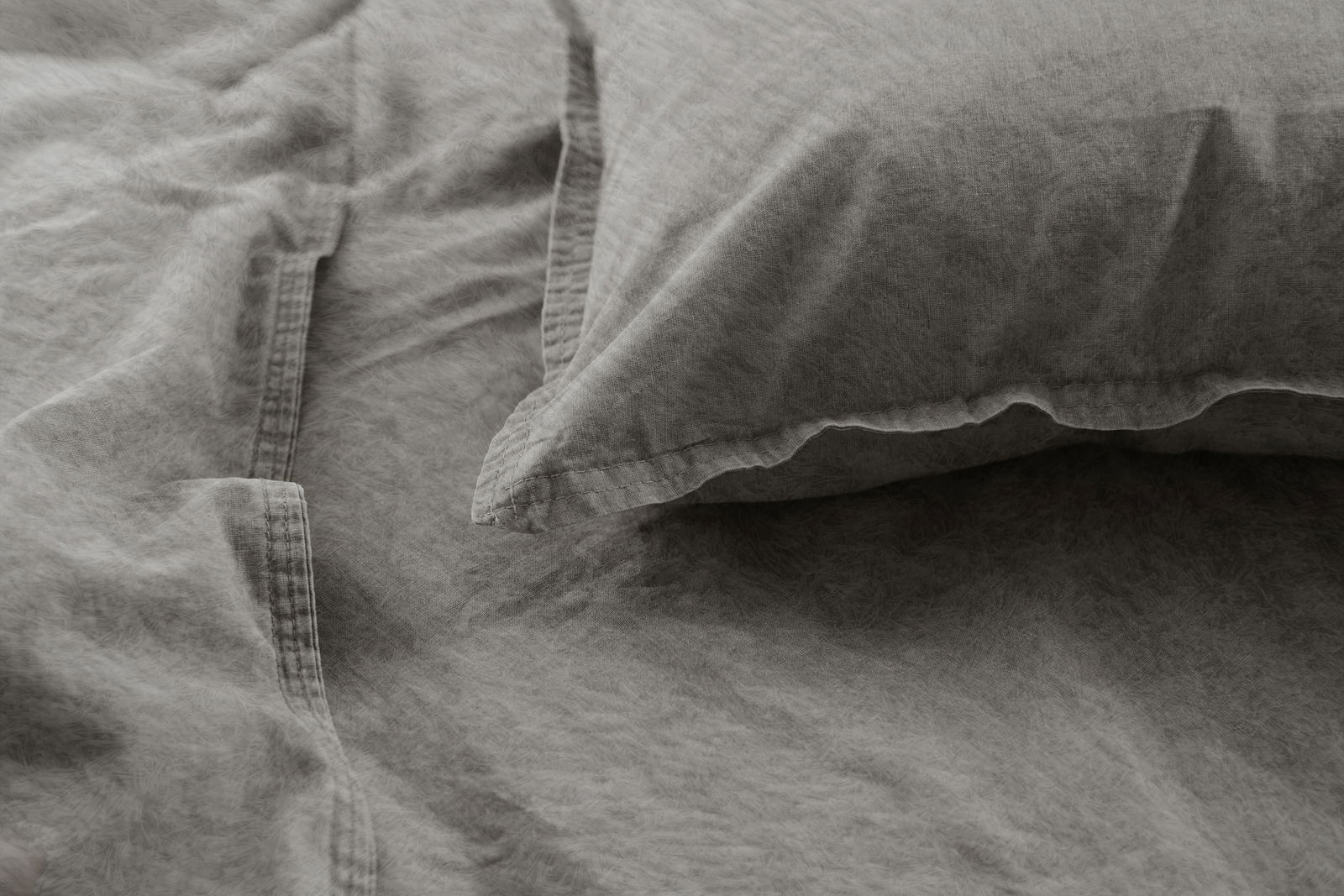 Graue, stone-washed Bettwäsche mit Kissenbezug in Nahaufnahme, seitliche Perspektive