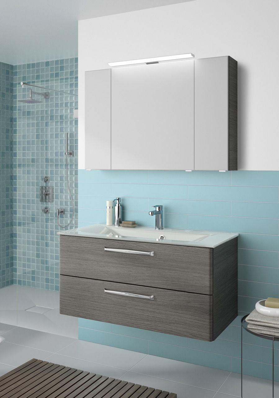 Moderner Badblock mit grauen Schubladen und integriertem Waschbecken, frontal betrachtet.