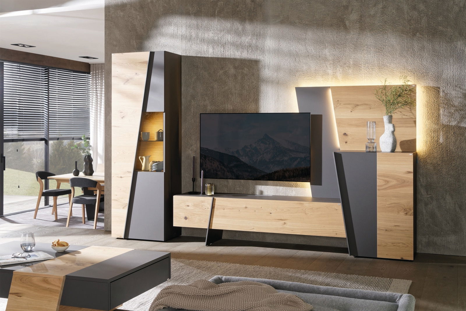 Voglauer Wandmeubel BEZATONO LIVING Moderne Wohnwand in Holzoptik mit grauen Akzenten, frontal fotografiert, mit integriertem TV und dekorativer Beleuchtung.
