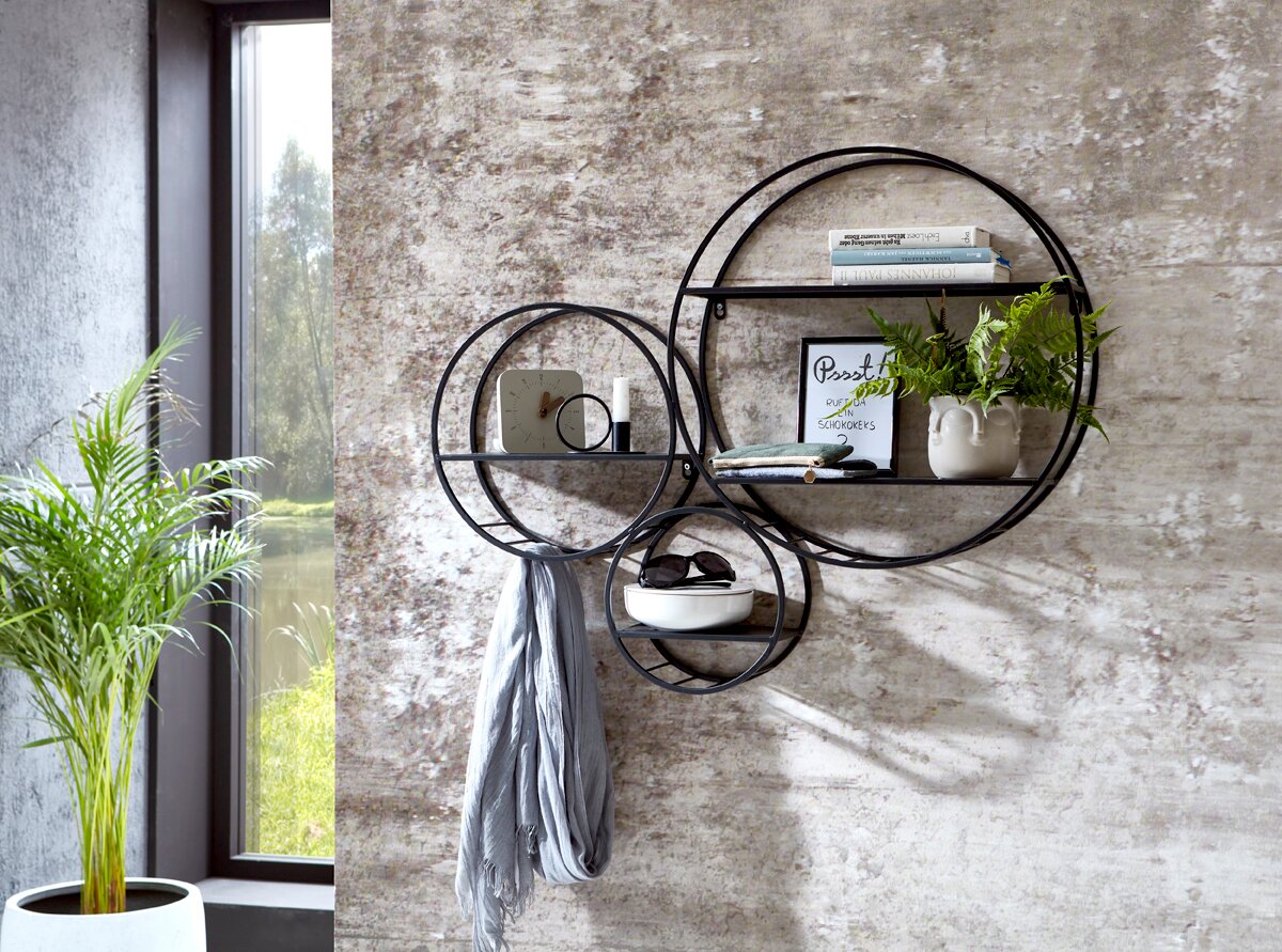 Zurbrüggen Wandregal Frontale Ansicht eines modernen Wandregals aus schwarzem Metall mit drei runden Rahmen und Ablagen, dekoriert mit Büchern, Bild, Pflanze und Accessoires vor einer Betonoptik-Wand