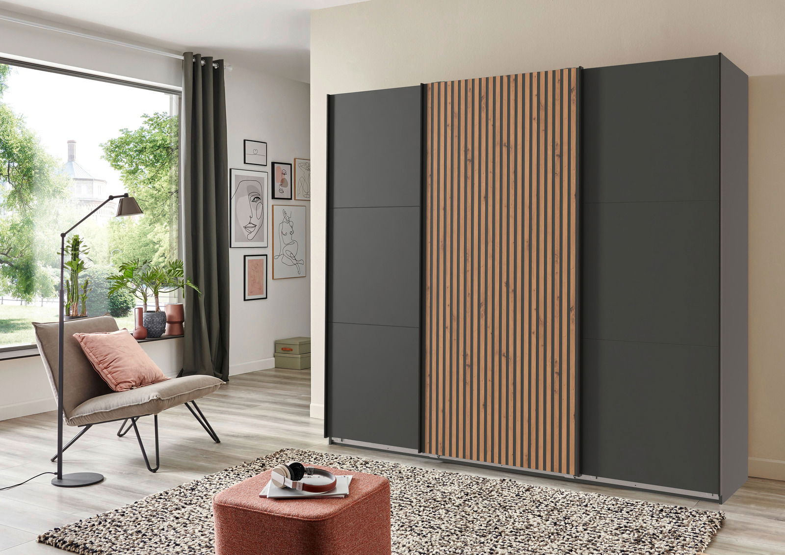 Moderner Schwebetürenschrank mit drei Türen, davon eine mit Holzlamellen, in einem stilvollen Wohnzimmer aus seitlicher Perspektive.