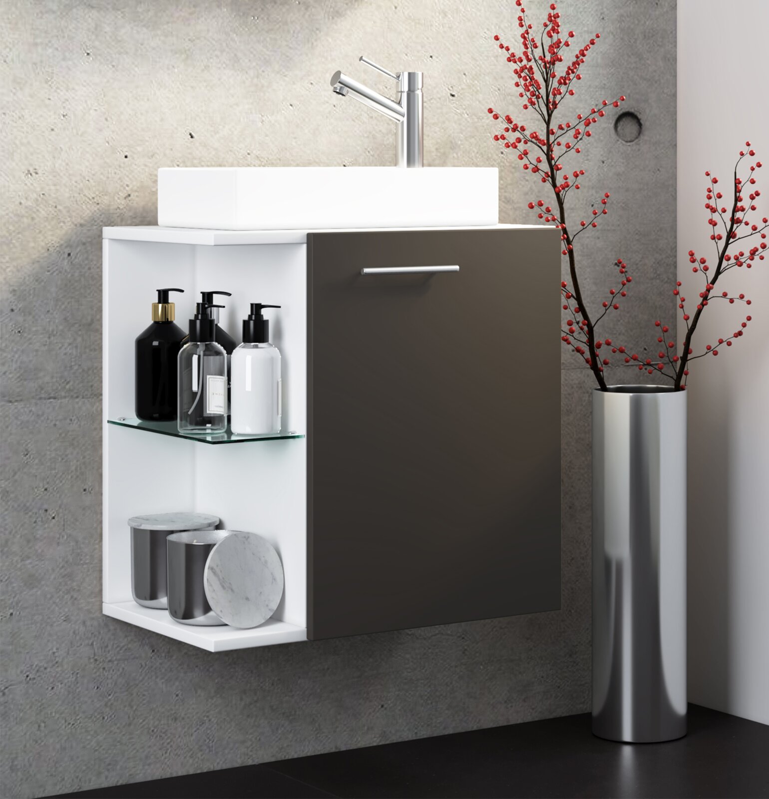 Modernes, wandhängendes Bad-Waschbecken mit weißem Korpus, dunkler Fronttür und offenem Regal mit Glasablage, oben verchromte Armatur; seitliche Vorderansicht (leicht von links) vor Betonwand, daneben Vase mit roten Zweigen.