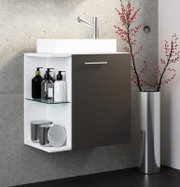 Modernes, wandhängendes Bad-Waschbecken mit weißem Korpus, dunkler Fronttür und offenem Regal mit Glasablage, oben verchromte Armatur; seitliche Vorderansicht (leicht von links) vor Betonwand, daneben Vase mit roten Zweigen.