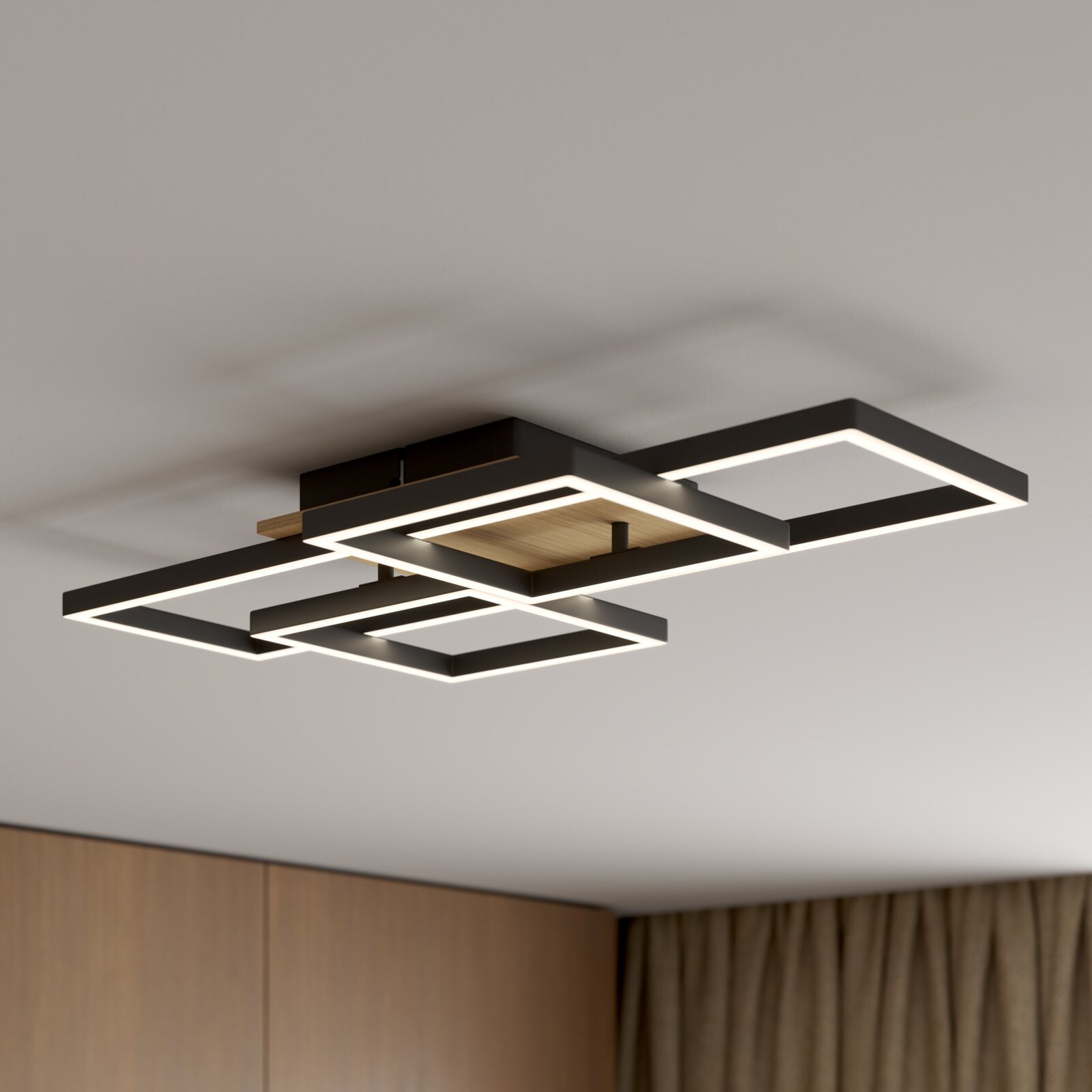 Novel LED-Deckenleuchte Worcester Moderne LED-Deckenleuchte mit drei überlappenden, rechteckigen Licht-Rahmen in Schwarz mit Holz-Detail, warmweiß leuchtend, in schräger Untersicht an der Zimmerdecke montiert