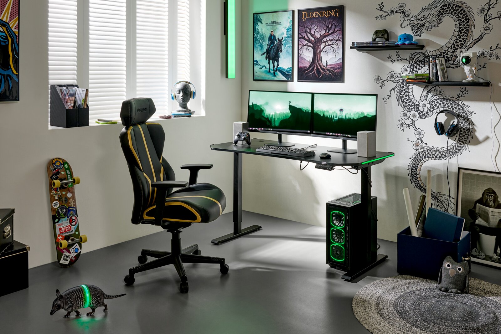 BXGAMING Gaming Stuhl GENIUS Modernes Gaming-Setup mit höhenverstellbarem Schreibtisch, Dual-Monitoren, schwarzem Gaming-Stuhl mit gelben Akzenten und PC-Tower mit grüner RGB-Beleuchtung; Perspektive: seitliche Frontansicht des gesamten Arbeitsplatzes.