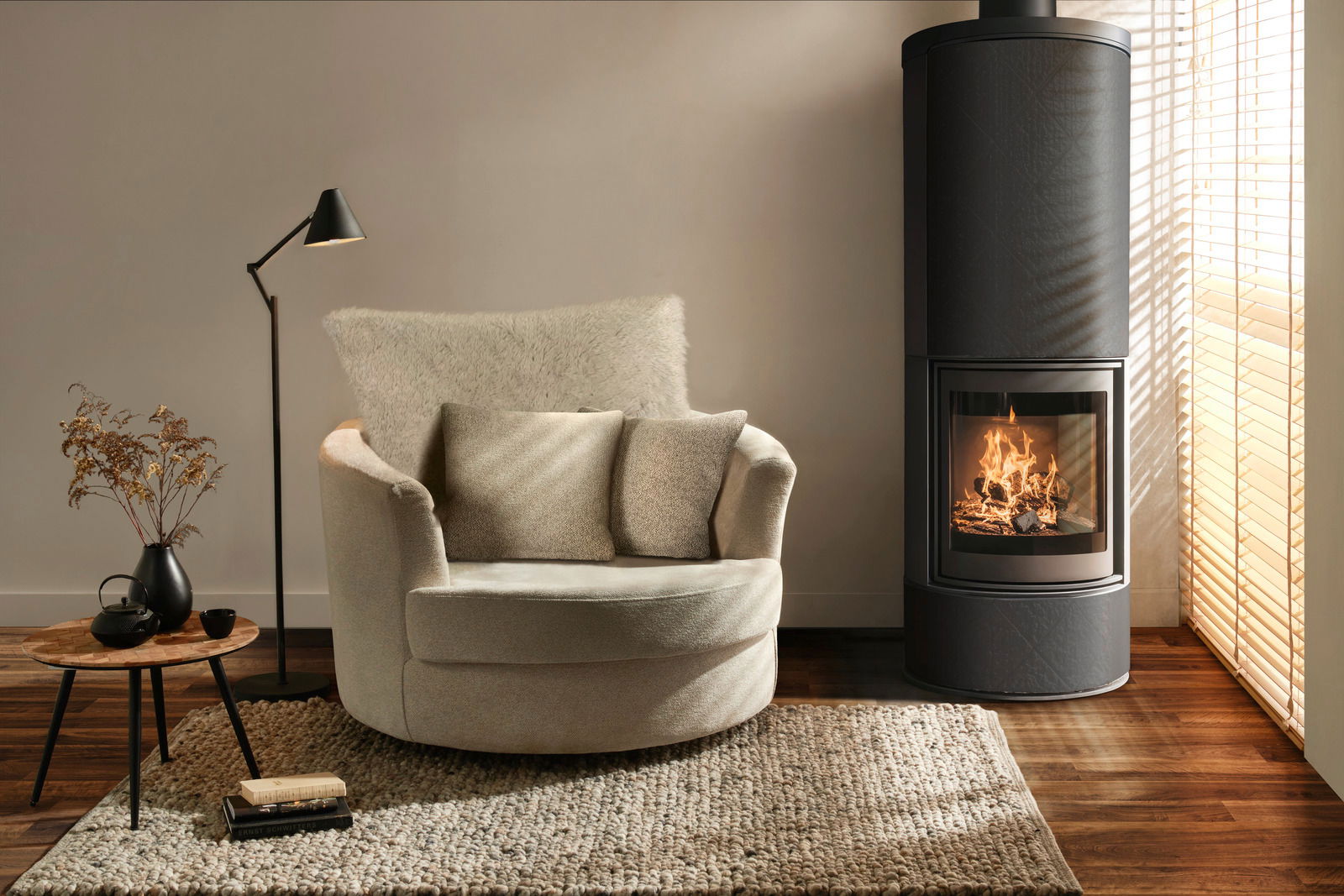 Gemütlicher cremefarbener Sessel mit Kissen, von vorne gesehen, neben einem modernen Kamin in einem stilvoll eingerichteten Wohnzimmer.