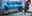 Moderner Gaming- und Arbeitsplatz mit drei Monitoren, LED-Beleuchtung, Gaming-Stuhl und Hochleistungs-PC am Fenster.