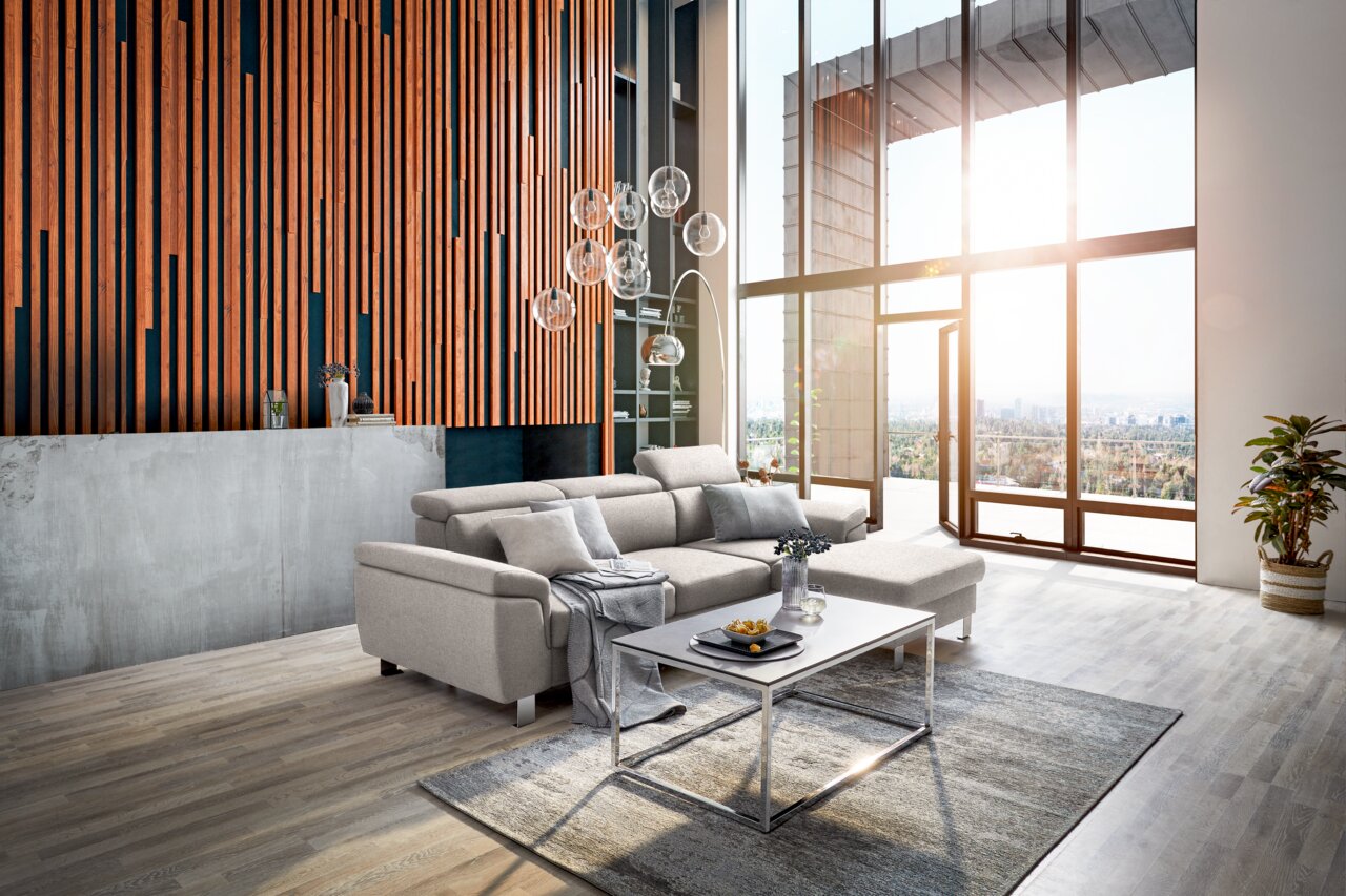 Z2 Ecksofa TIM Moderne Rundecke in einem hellen Wohnzimmer mit großen Fenstern, die einen Blick auf die Stadt bieten. Die Perspektive zeigt die Rundecke von vorne, mit einem Couchtisch und Dekorationen im Vordergrund.