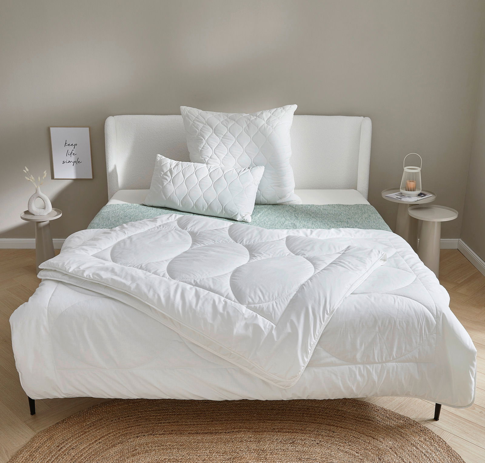 Gemütliches Schlafzimmer mit einem weißen Winterbett 155x220 cm, dekoriert mit passenden Kissen auf einem modernen Bettgestell. Frontalansicht.