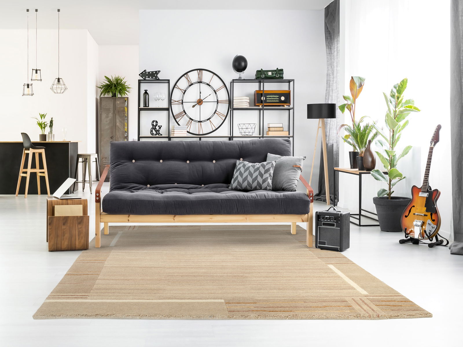Moderner Wohnraum mit einem beigen Wollteppich im Vordergrund, der vor einem grauen Sofa liegt. Der Raum ist stilvoll eingerichtet mit Pflanzen, einer Gitarre und einem großen Wanduhr. Die Perspektive zeigt den Teppich von vorne.
