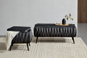 Zwei moderne, dunkelgraue Hocker mit eleganter, gefalteter Polsterung auf einem hellen Teppich. Einer der Hocker ist mit einer weißen Decke dekoriert, während der andere ein Tablett mit einer Vase und Schalen trägt. Perspektive: Frontalansicht.