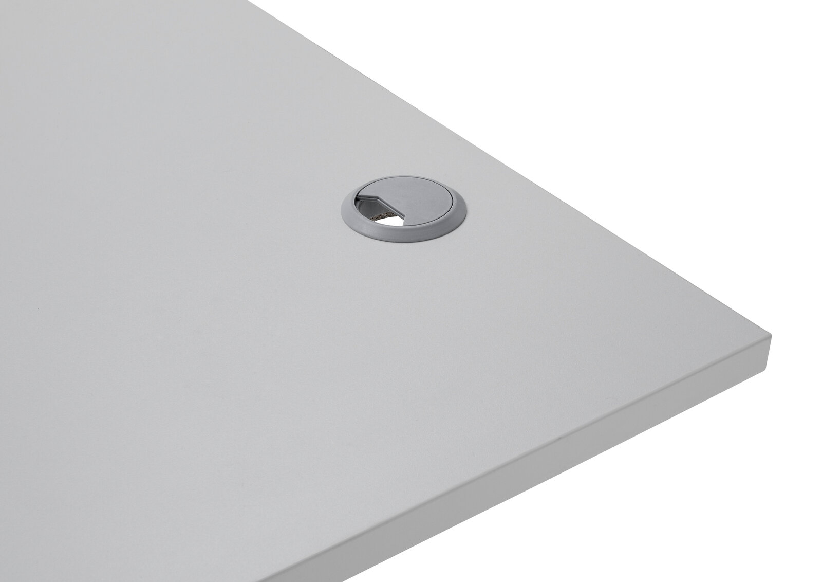 Nahaufnahme einer grauen Tischplatte mit Kabeldurchlass, perspektivisch von oben rechts fotografiert.