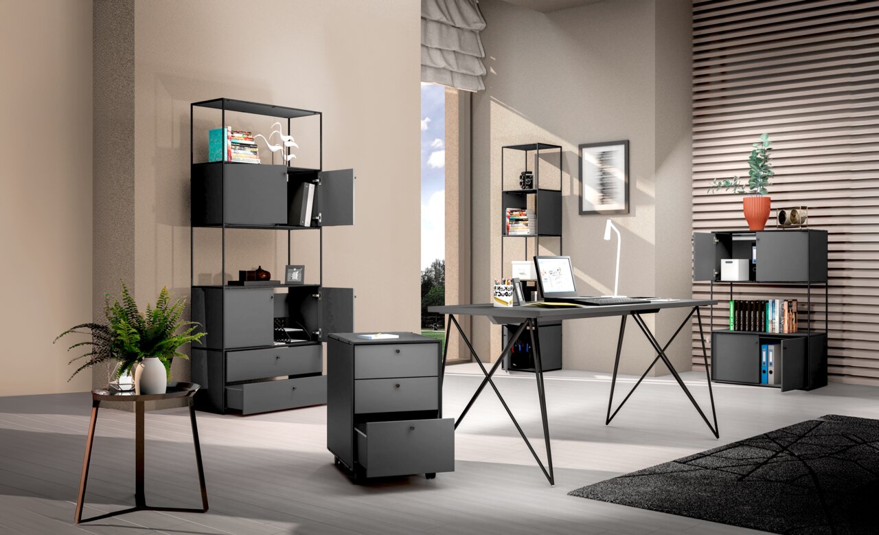Moderne Büromöbel in einem stilvollen Raum, darunter ein Winkelschreibtisch mit Kommode, Aktenregale und ein Rollcontainer, aus der Perspektive eines offenen Raumes betrachtet.