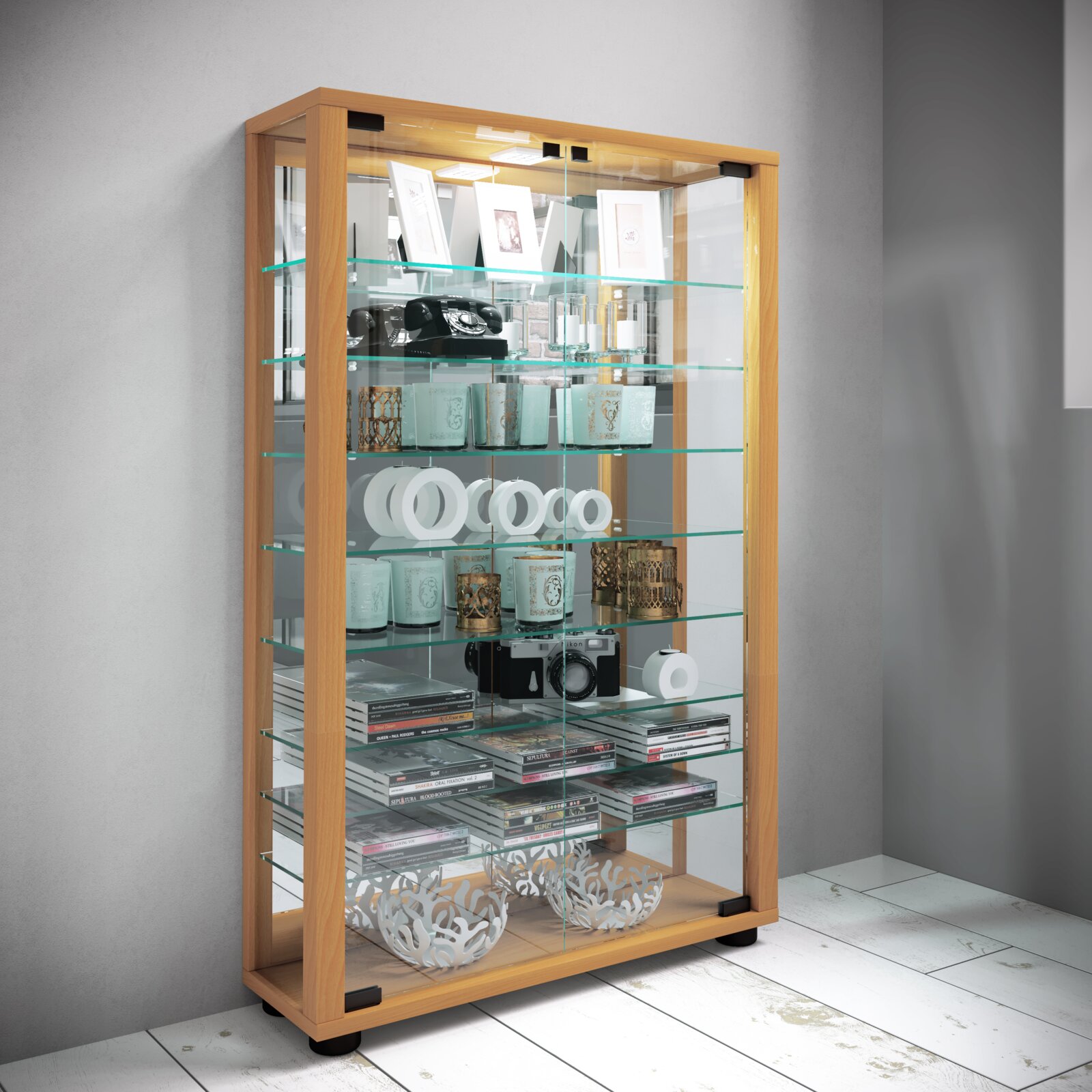 Hohe Glasvitrine mit hellem Holzrahmen, Glastüren und mehreren Glasböden, dekorativ bestückt; Ansicht schräg von vorne (leicht von links)