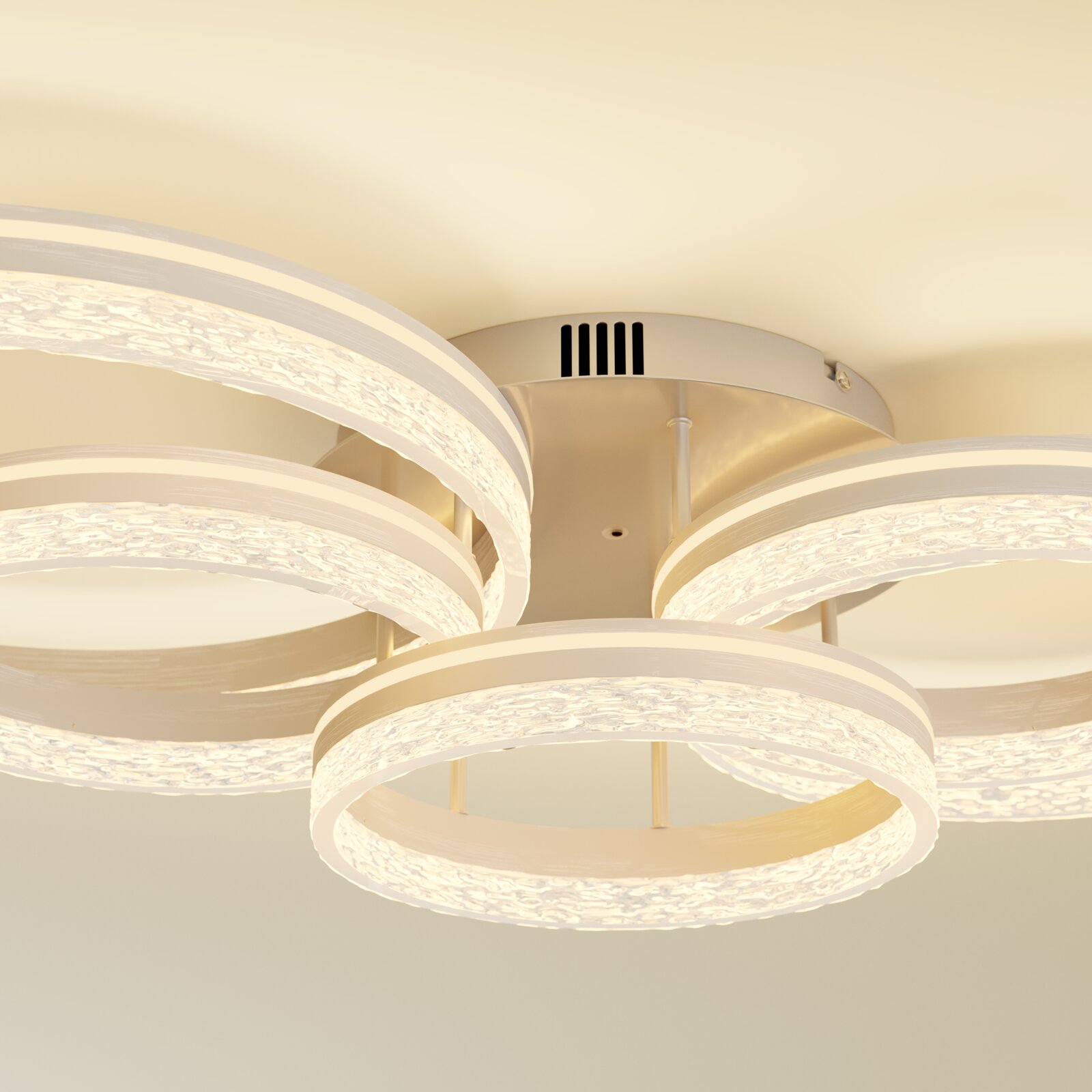 Moderne LED-Deckenleuchte mit mehreren leuchtenden Ringelementen und strukturierter Acryloptik in warmweiß, Ansicht von unten (Untersicht) an der Decke montiert