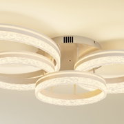 Moderne LED-Deckenleuchte mit mehreren leuchtenden Ringelementen und strukturierter Acryloptik in warmweiß, Ansicht von unten (Untersicht) an der Decke montiert