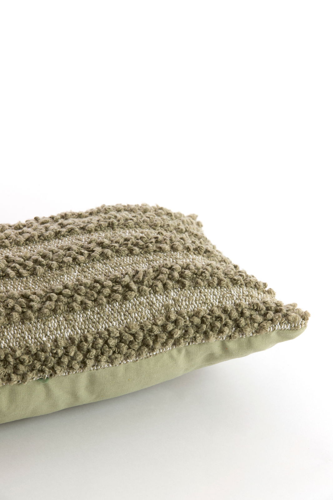 Nahaufnahme eines strukturierten, grünen Kissens mit Streifenmuster, seitliche Perspektive