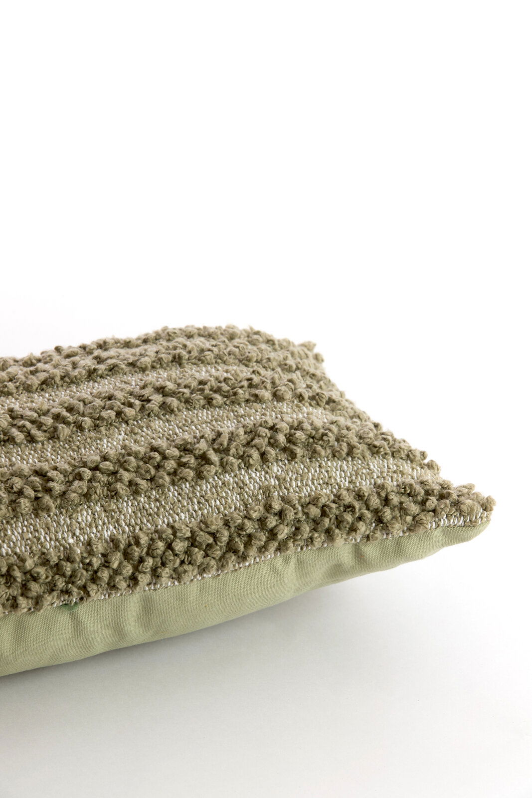 Nahaufnahme eines strukturierten, grünen Kissens mit Streifenmuster, seitliche Perspektive