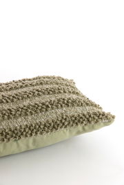 Nahaufnahme eines strukturierten, grünen Kissens mit Streifenmuster, seitliche Perspektive