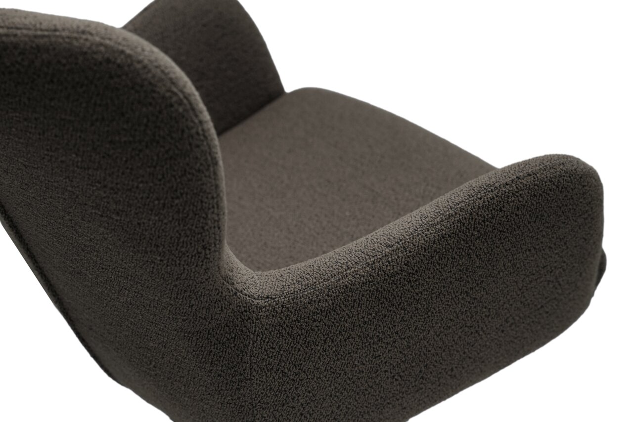 Close-up van een donkergrijze stoffen fauteuil, gezien vanaf de zijkant