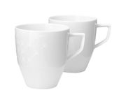 Zwei weiße Becher mit Henkel, einer mit dezentem Muster, aus seitlicher Perspektive fotografiert.