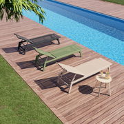 Drei Sonnenliegen in verschiedenen Farben (schwarz, grün, beige) auf einer Holzterrasse neben einem Pool, aus der Vogelperspektive betrachtet.