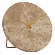 Nahaufnahme einer runden Uhr aus braunem Marmor mit goldenen Zeigern und minimalistischen Markierungen, seitliche Perspektive.