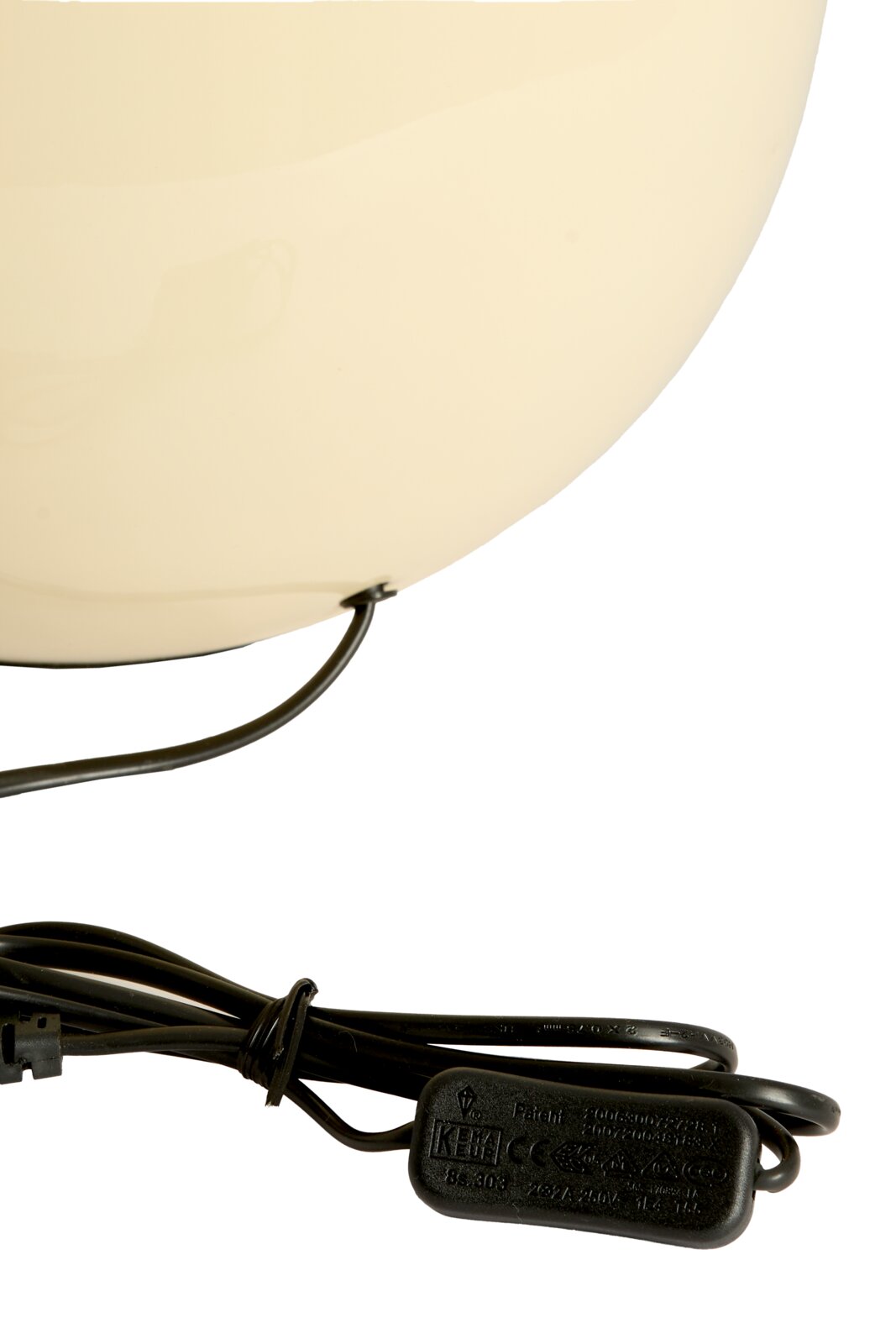 Close-up van een crèmekleurige lampvoet met zwarte kabel en schakelaar, gezien vanaf de zijkant.