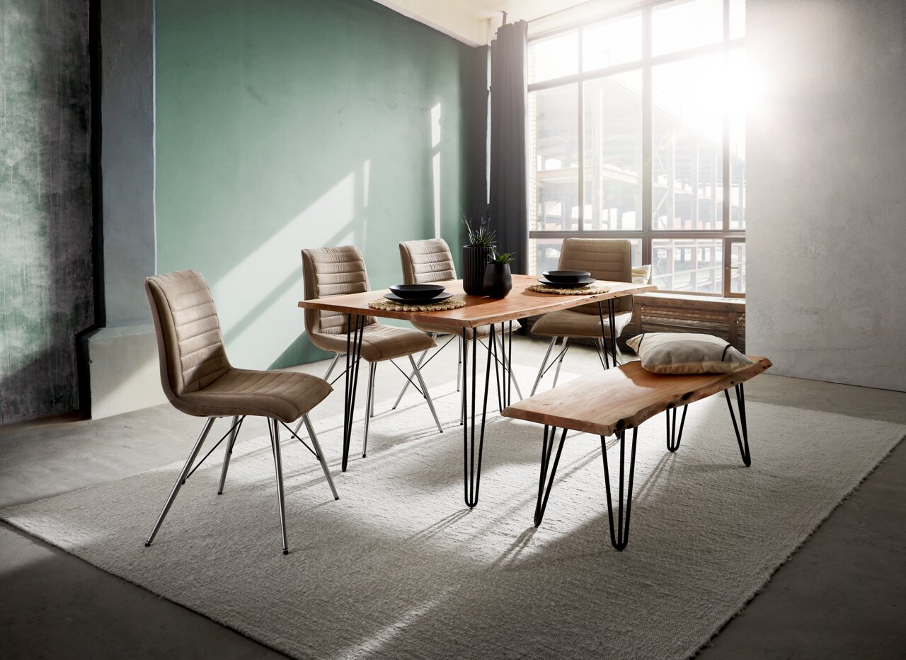 Moderner Essbereich mit Holztisch und Bank, umgeben von vier gepolsterten Stühlen, in einem lichtdurchfluteten Raum mit großen Fenstern, seitliche Perspektive.