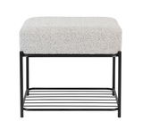 Moderner Hocker mit gepolsterter Sitzfläche in Grau und schwarzem Metallgestell, Vorderansicht.