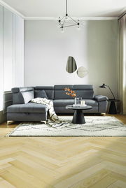 Moderne graue Eckcouch in einem stilvoll eingerichteten Wohnzimmer, seitliche Perspektive