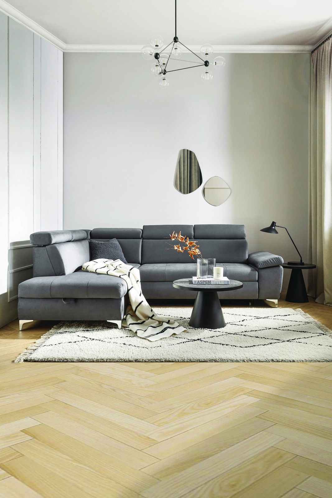 Moderne graue Eckcouch in einem stilvoll eingerichteten Wohnzimmer, seitliche Perspektive