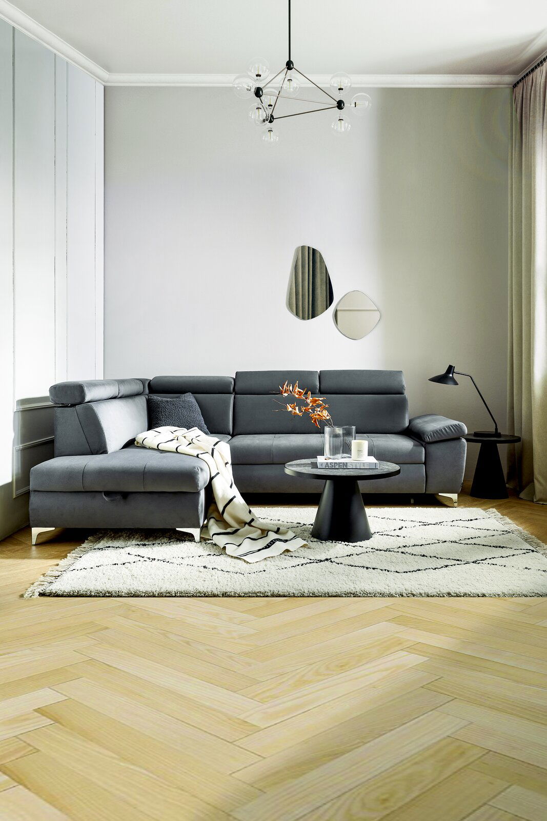 Moderne graue Eckcouch in einem stilvoll eingerichteten Wohnzimmer, seitliche Perspektive