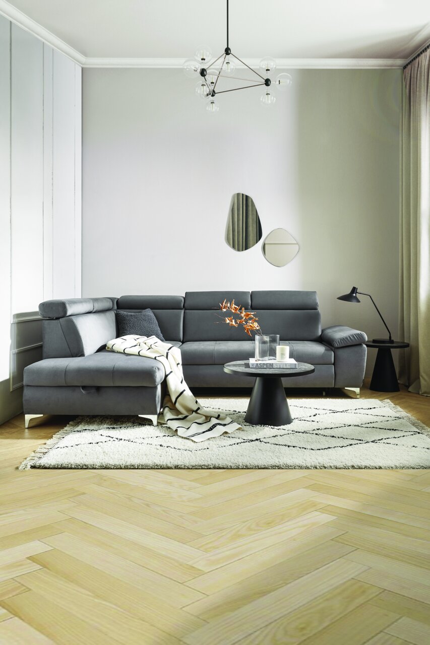 Moderne graue Eckcouch in einem stilvoll eingerichteten Wohnzimmer, seitliche Perspektive