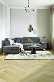 Moderne graue Eckcouch in einem stilvoll eingerichteten Wohnzimmer, seitliche Perspektive