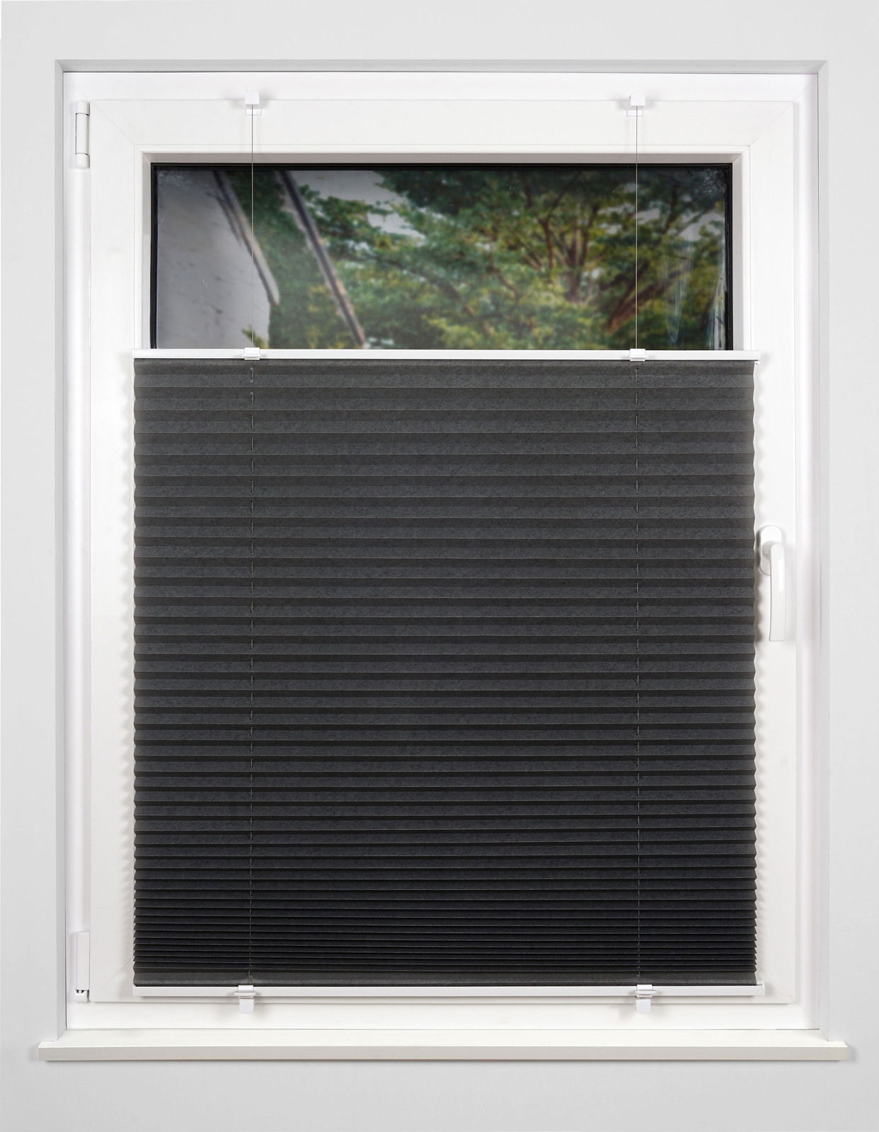 Schwarzes Plissee gefädelt, montiert an einem weißen Fensterrahmen, von innen fotografiert.