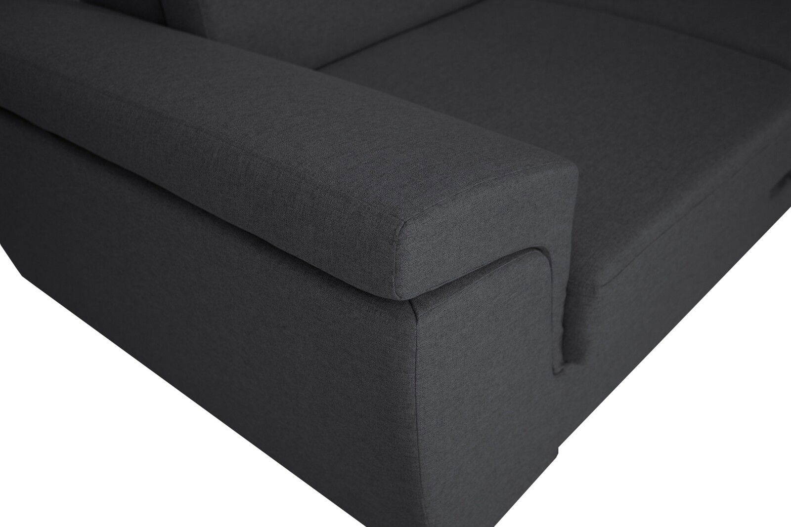 Nahaufnahme einer dunkelgrauen Sofaecke mit Armlehne, Perspektive von oben.