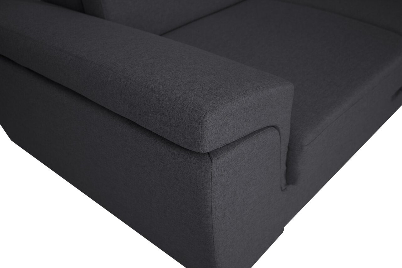 Nahaufnahme einer dunkelgrauen Sofaecke mit Armlehne, Perspektive von oben.