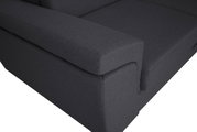 Nahaufnahme einer dunkelgrauen Sofaecke mit Armlehne, Perspektive von oben.