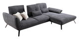 Graues Ecksofa mit Rillenstruktur, zwei weißen und zwei grauen Kissen, aus seitlicher Perspektive fotografiert.