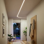 Moderne, geschwungene LED-Deckenlichtlinie in einem hellen Flur mit Garderobenpaneel und Fensterfront, aufgenommen aus leichtem Untersichtwinkel nach oben zur Decke