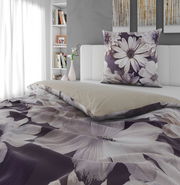 Wendebettwäsche mit floralem Muster in Lila- und Beigetönen auf einem Bett, seitliche Perspektive